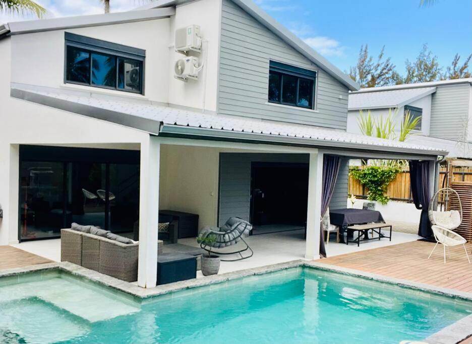 Piscine chauffée, terrasse en bois et salon extérieur couvert de la villa