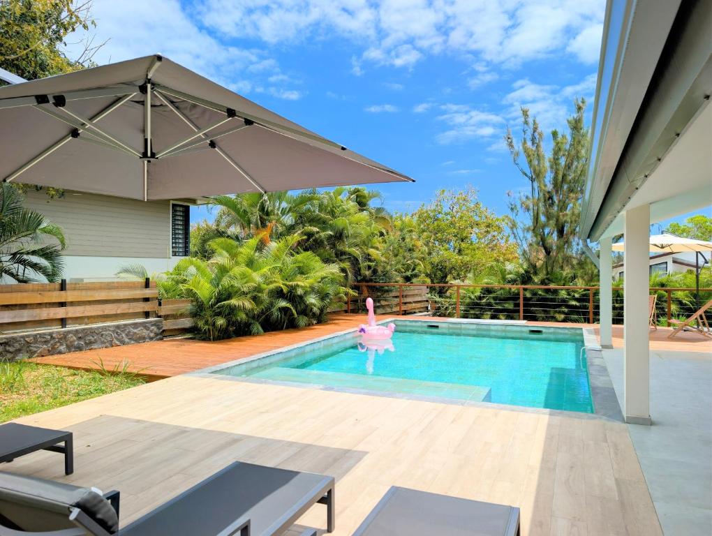 Piscine chauffée avec parasol et transats sur la terrasse