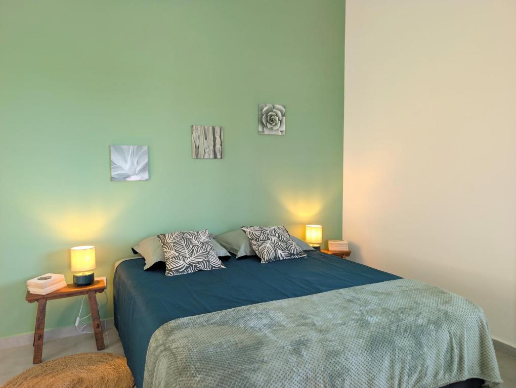 Chambre verte avec grand lit double et chevets