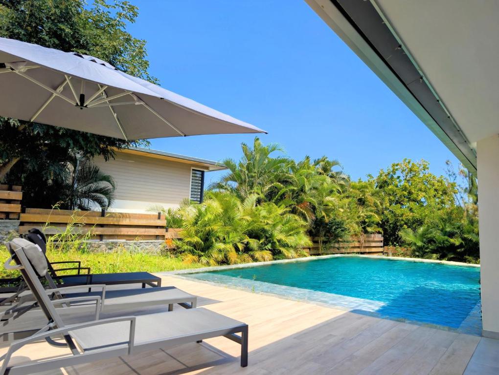 Terrasse ensoleillée avec transats au bord de la piscine