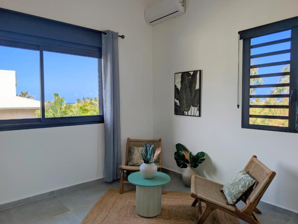 Coin salon lumineux avec vue mer et fauteuils en rotin