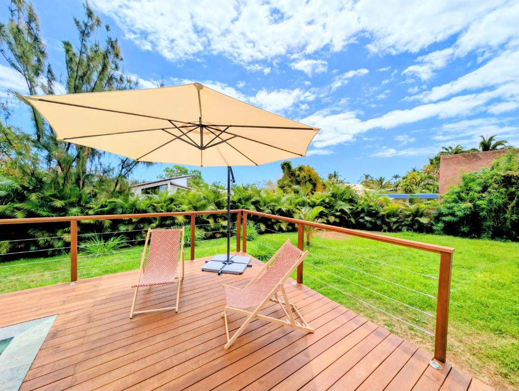 Terrasse en bois avec parasol et transats sur le jardin