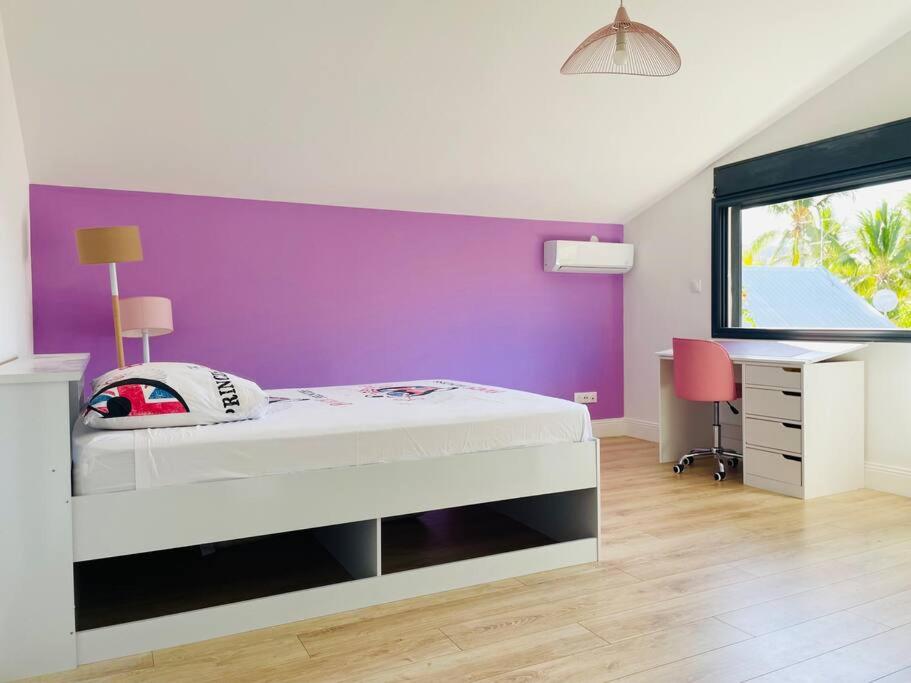 Chambre enfant climatisée avec bureau et vue sur les palmiers