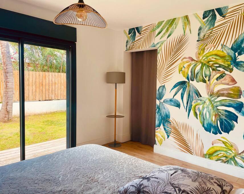 Chambre climatisée avec papier peint tropical et accès direct au jardin